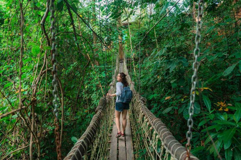 A woman walking on rope bridge